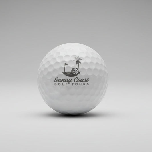 Golf ball with 'Sunny Coast Golf Tours' branding on a white surface.