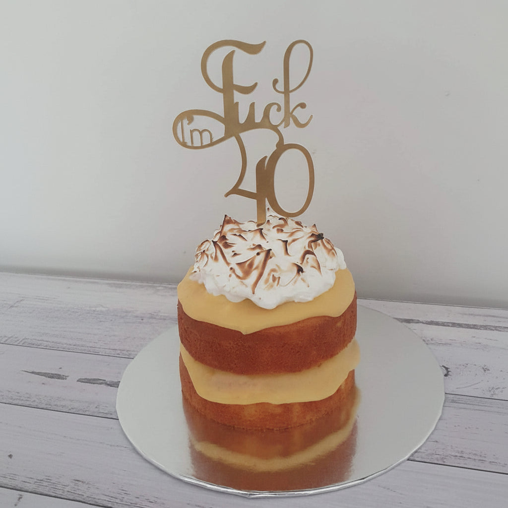 Layered cake with whipped cream and a gold 'I'm 40' topper on a white background