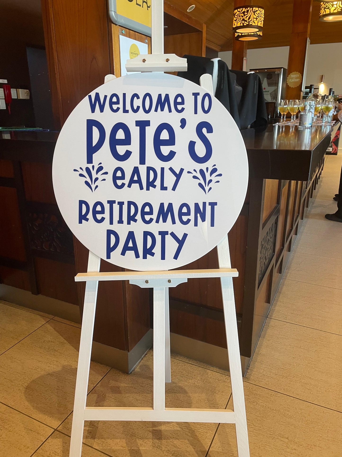 Decorative sign for Pete's early retirement party on an easel at the entryway to a bar