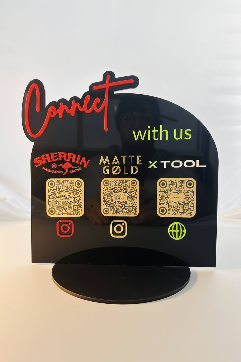 Black sign with QR codes and brand names on a white background