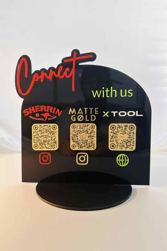 Black sign with QR codes and brand names on a white background