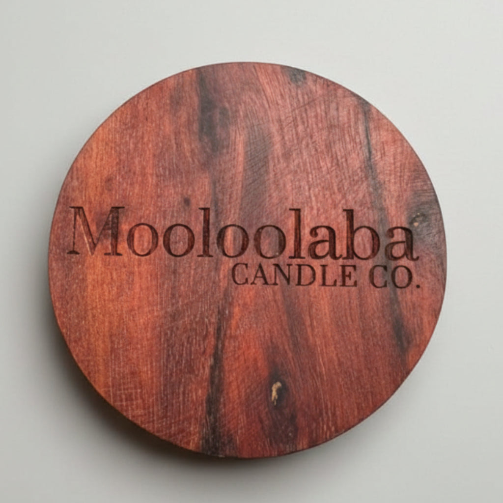 Wooden coaster with 'Mooloolaba Candle Co.' branding on a gray background