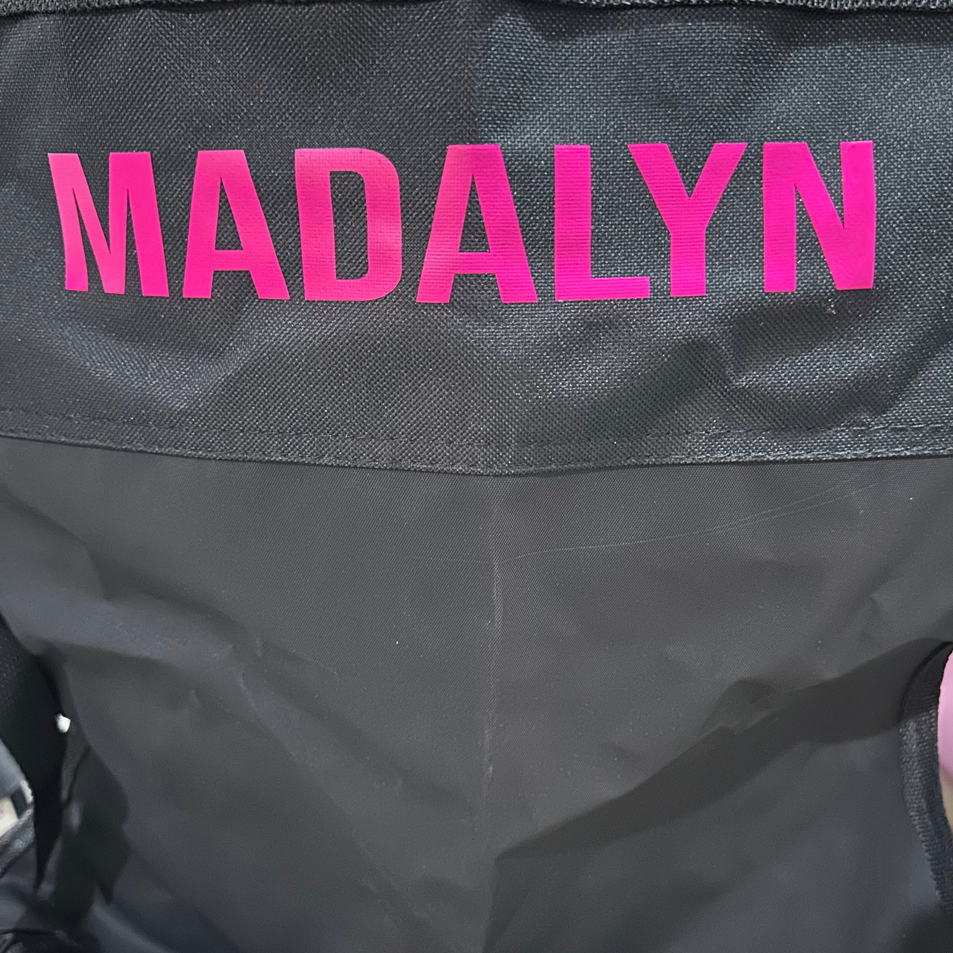 Black chair with 'MADALYN' in pink on the back.