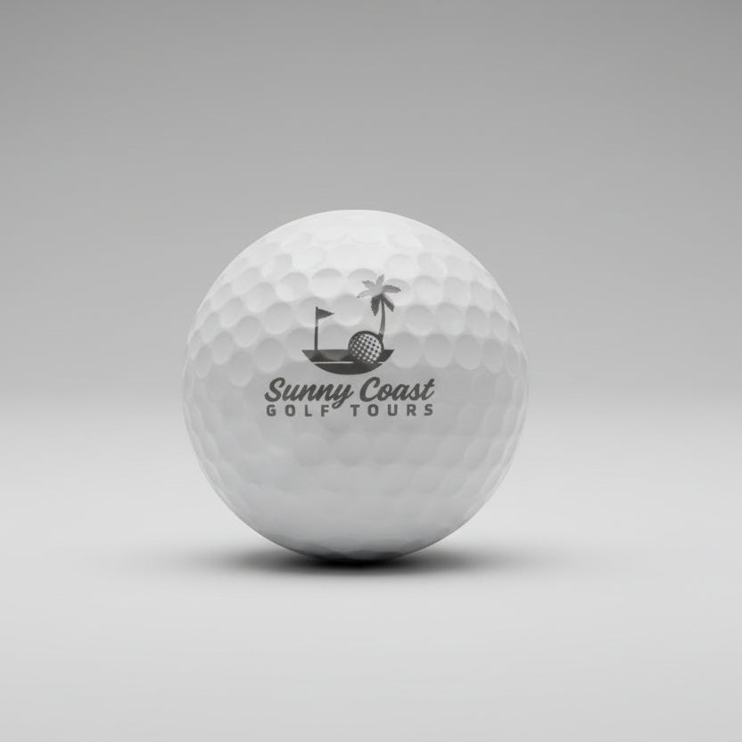 Golf ball with 'Sunny Coast Golf Tours' branding on a white surface.