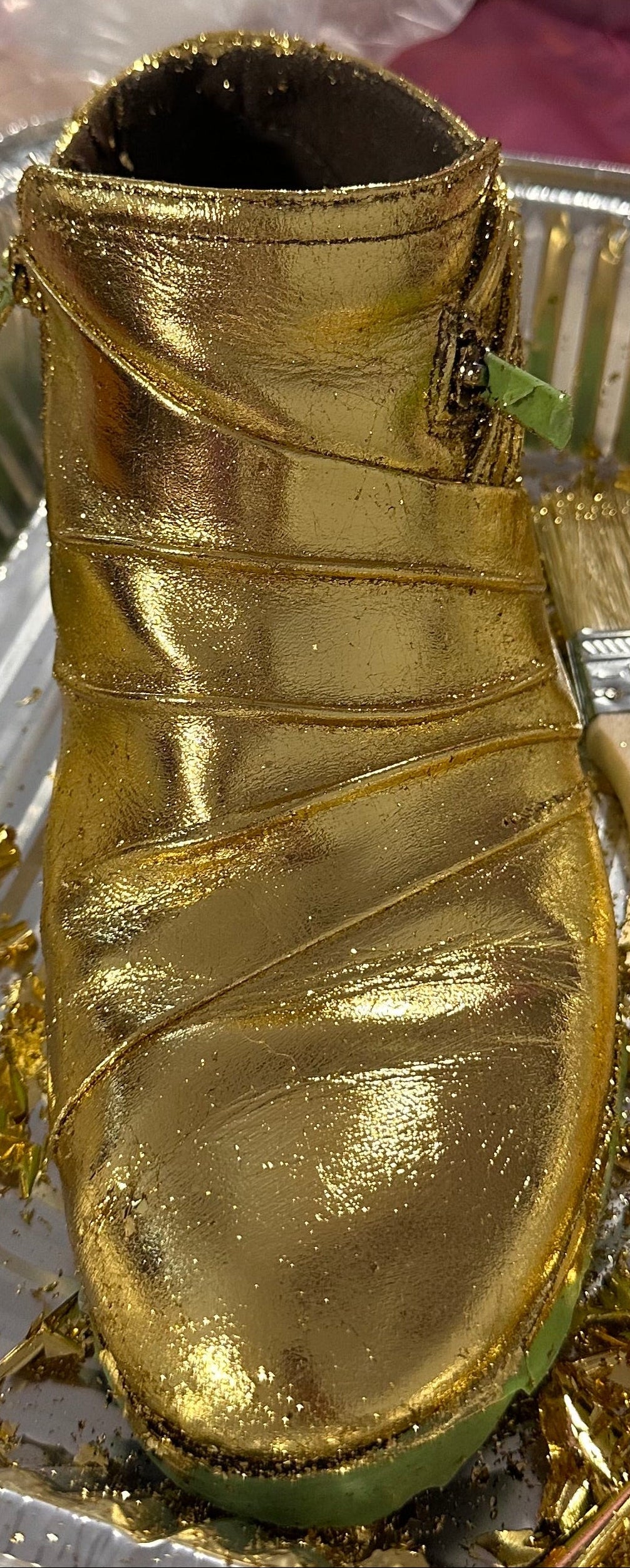 Gold Foiled boot inside a foil container 