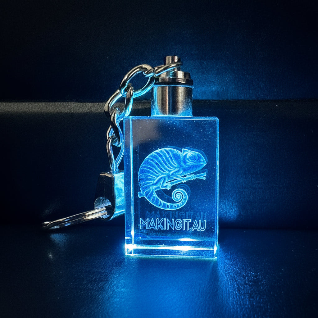 Keychain with logo engraved design and text on a dark background