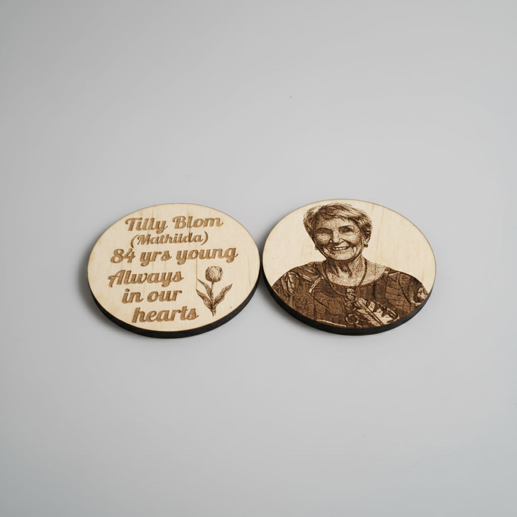 Two wooden circles with engraved text and a portrait on a metallic surface.