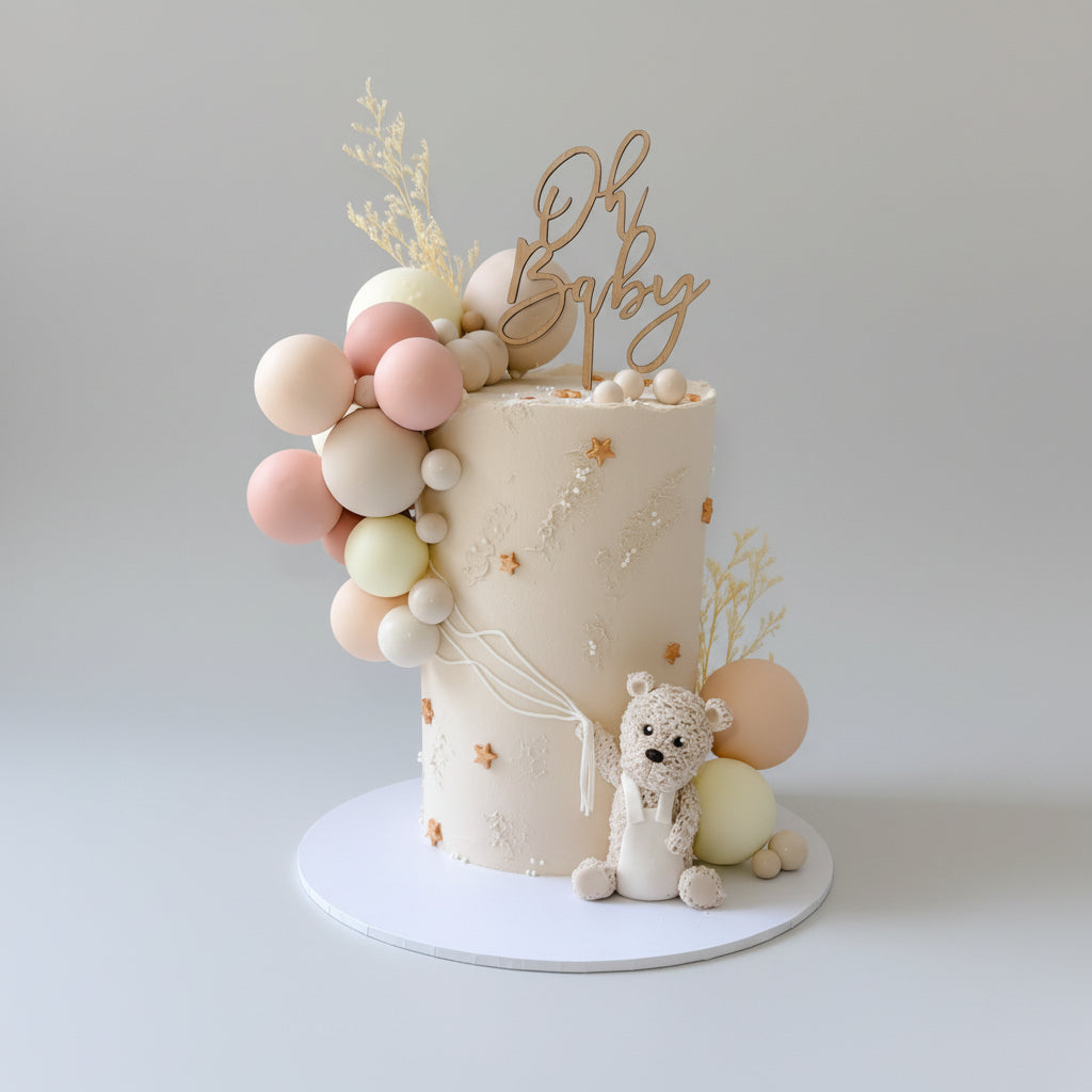 Baby shower cake with balloons and 'Oh Baby' Timber Cake topper on a white background