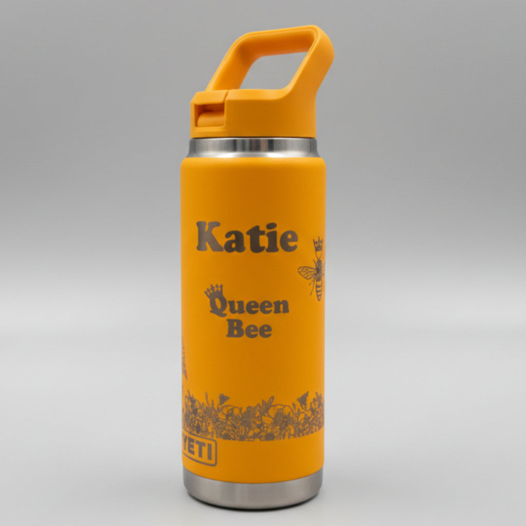 Yellow waterbottle with 'katie bee' branding on a white surface