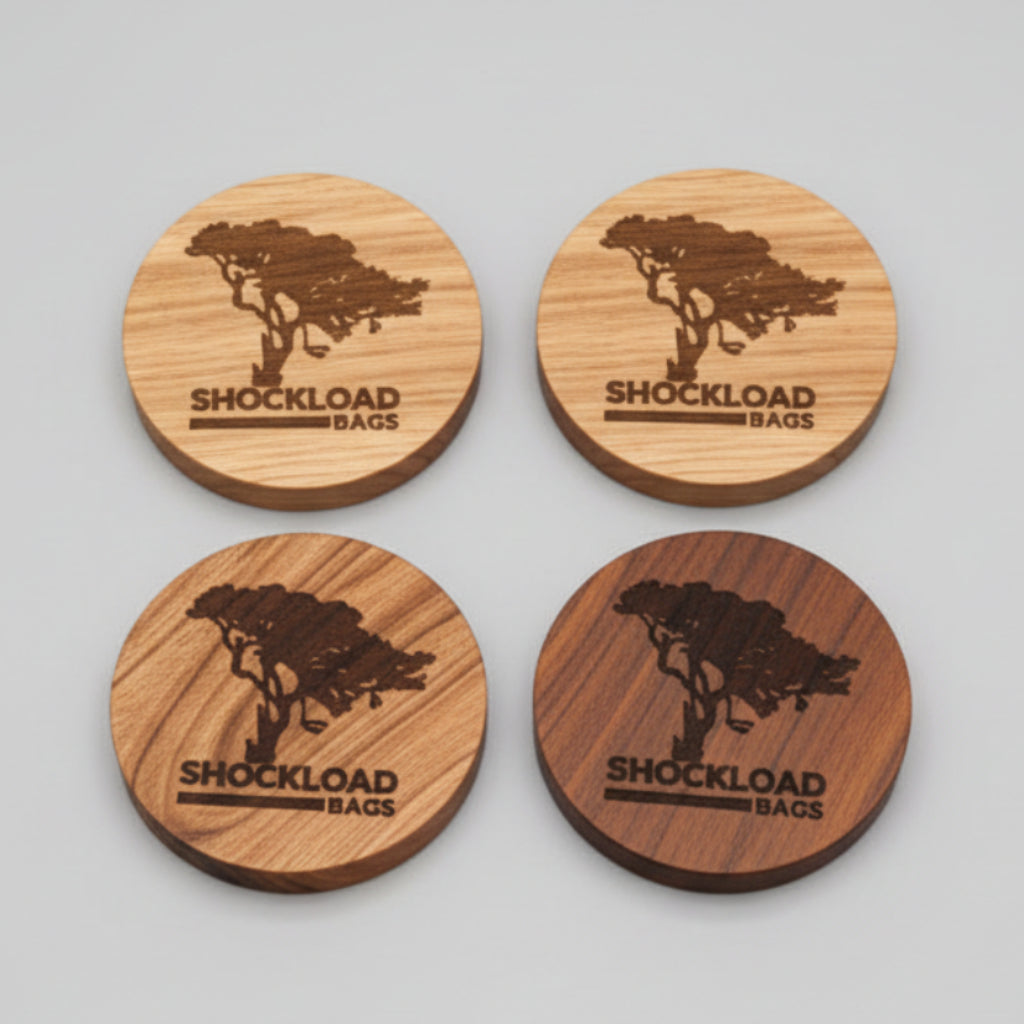 Four wooden round coasters with an engraved logo on a wooden surface.